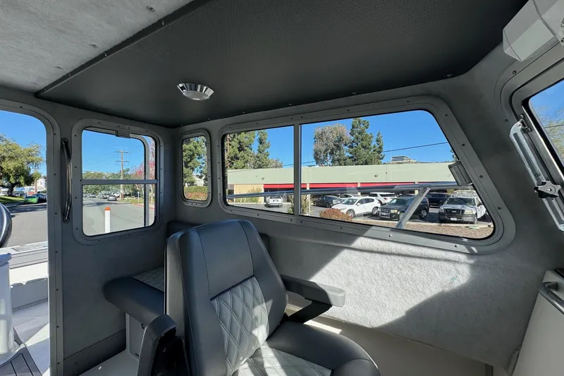 Slide: The Image of Interior of 2026 Defiance Admiral 250 EX boat, featuring seating and large windows. - 87