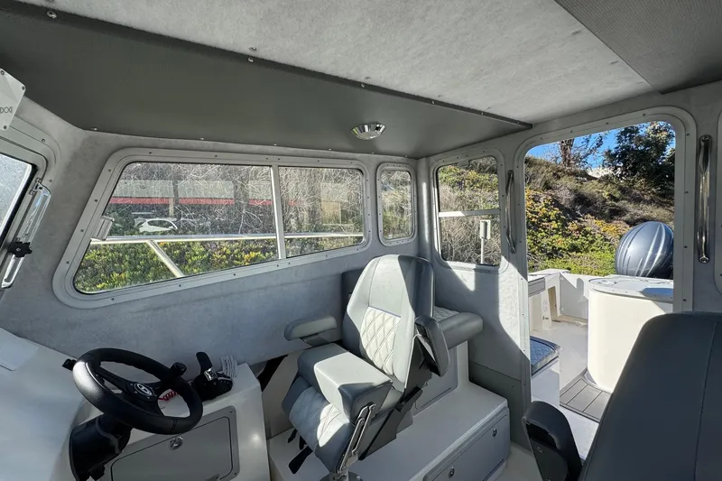 Slide: The Image of Interior of 2026 Defiance Admiral 250 EX boat, featuring steering wheel and seating. - 88