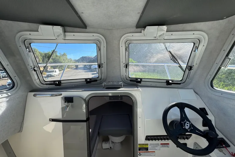 Slide: The Image of Interior view of 2026 Defiance Admiral 250 EX boat cockpit with steering wheel and windows. - 89
