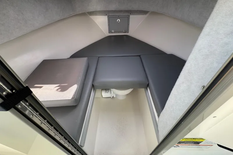 Slide: The Image of 2026 Defiance Admiral 250 EX cabin interior with cushioned seating and storage compartment. - 90