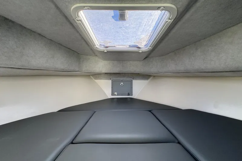 Slide: The Image of Interior cabin of 2026 Defiance Admiral 250 EX boat with cushioned seating and overhead hatch. - 93