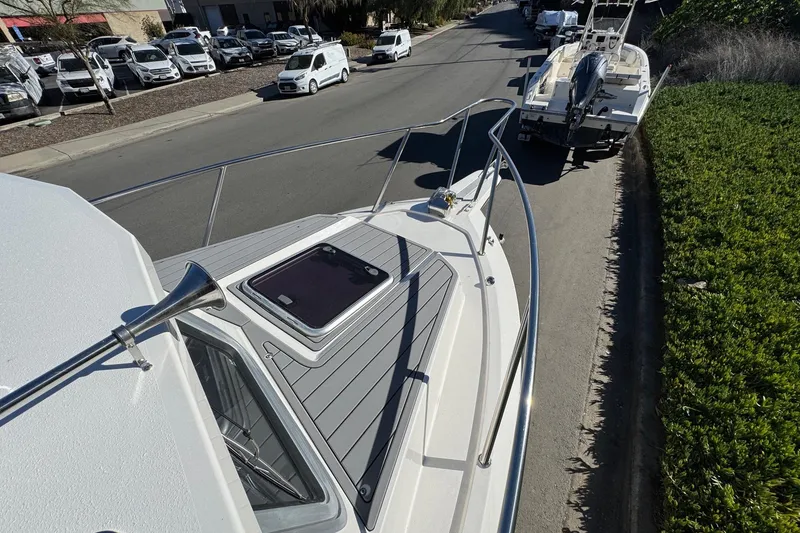 Slide: The Image of 2026 Defiance Admiral 250 EX boat on a trailer, parked on a street. - 99