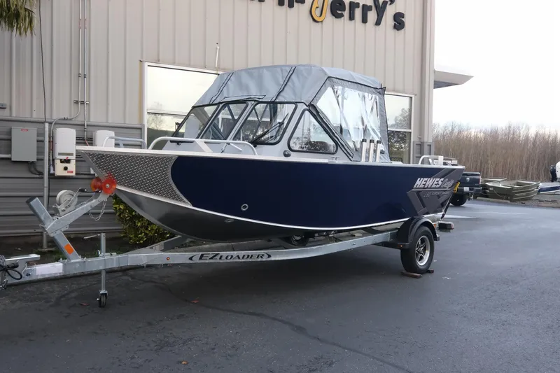 The Image of 2026 Hewescraft 180 Sportsman boat on trailer outside a building. - 1