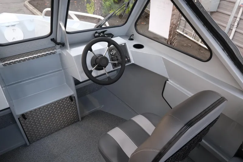 Slide: The Image of Interior of 2026 Hewescraft 180 Sportsman boat, featuring steering wheel and seating. - 12