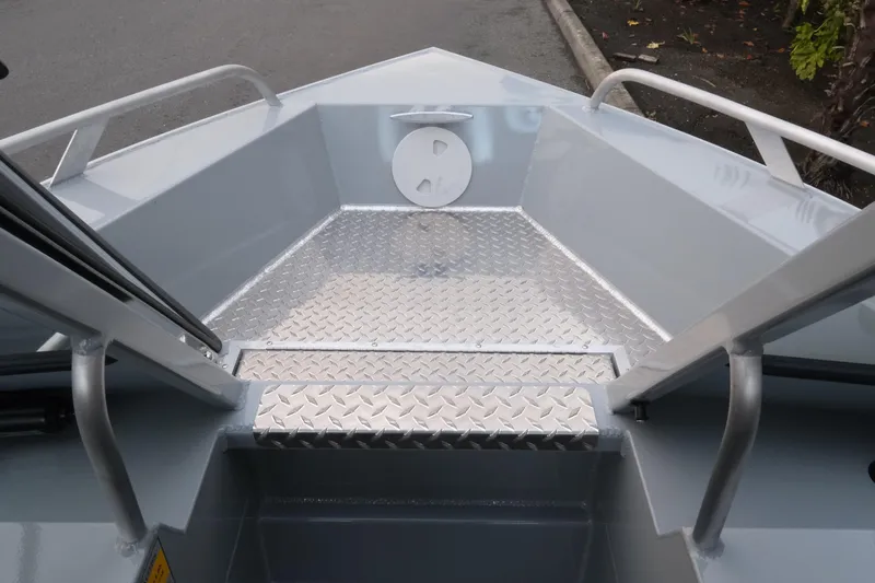 Slide: The Image of 2026 Hewescraft 180 Sportsman boat bow with diamond plate flooring and sturdy railings. - 16