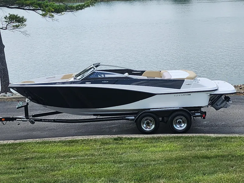 Slide: The Image of 2016 Glastron GT 205 boat on trailer by a lake. - 0
