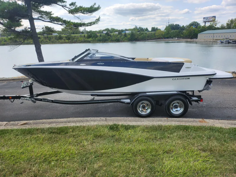 Slide: The Image of 2016 Glastron GT 205 boat on trailer by a lake. - 10