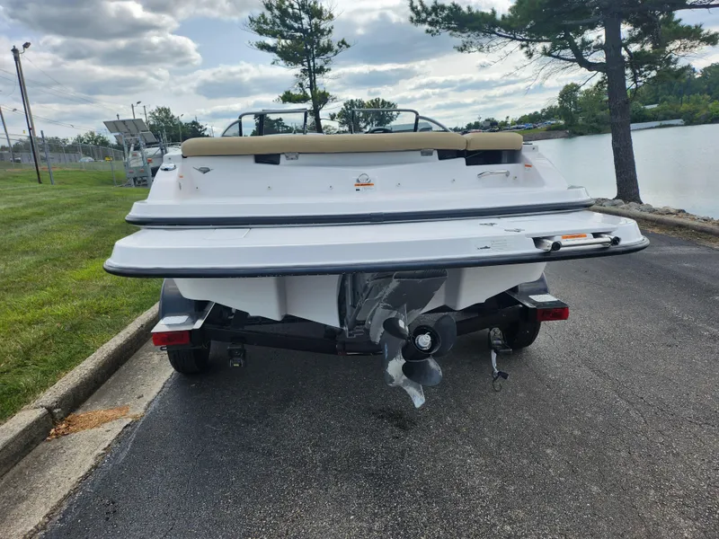 Slide: The Image of 2016 Glastron GT 205 boat parked near a lake on a cloudy day. - 2