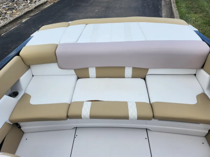 Slide: The Image of 2016 Glastron GT 205 boat interior with beige and white cushioned seating. - 22