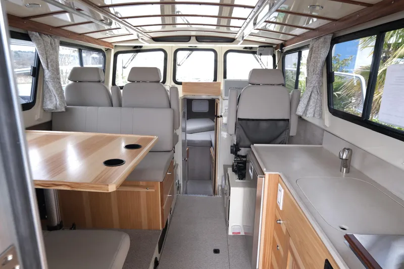 Slide: The Image of 2025 Hewescraft 290 Adventure interior with seating, table, and kitchenette. - 10