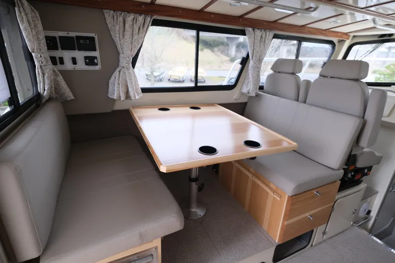 Slide: The Image of Interior of 2025 Hewescraft 290 Adventure, featuring a cozy dining area with seating and table. - 11