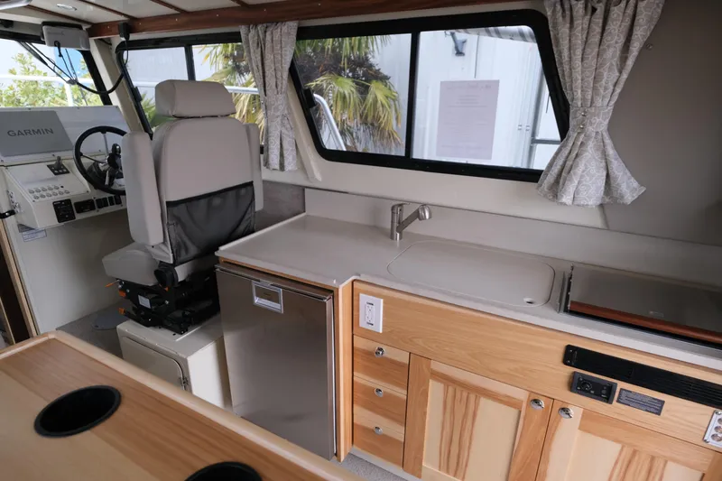 Slide: The Image of 2025 Hewescraft 290 Adventure interior with helm, kitchenette, and modern amenities. - 12