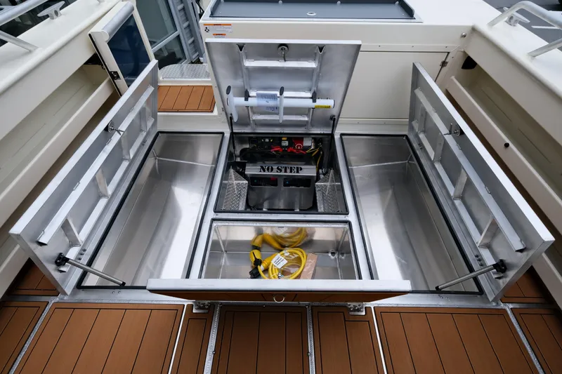 Slide: The Image of 2025 Hewescraft 290 Adventure boat storage compartments open, showcasing interior space and equipment. - 21