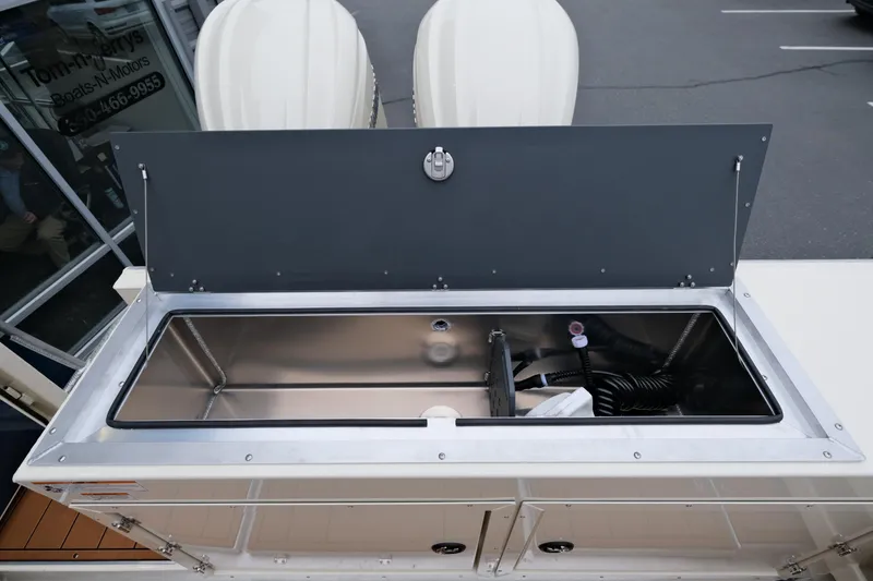 Slide: The Image of 2025 Hewescraft 290 Adventure boat storage compartment with open lid, showcasing interior details. - 22