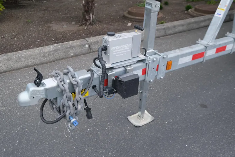 Slide: The Image of Trailer hitch and chains of a 2025 Hewescraft 290 Adventure boat trailer. - 23