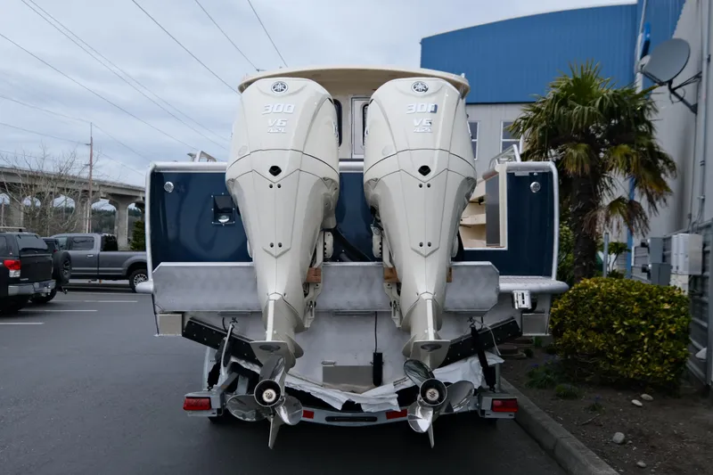 Slide: The Image of 2025 Hewescraft 290 Adventure with dual 300 V6 outboard engines, parked outdoors. - 5
