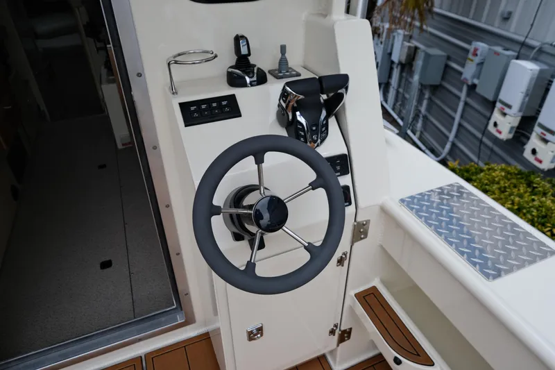 Slide: The Image of 2025 Hewescraft 290 Adventure helm with steering wheel and controls. - 9