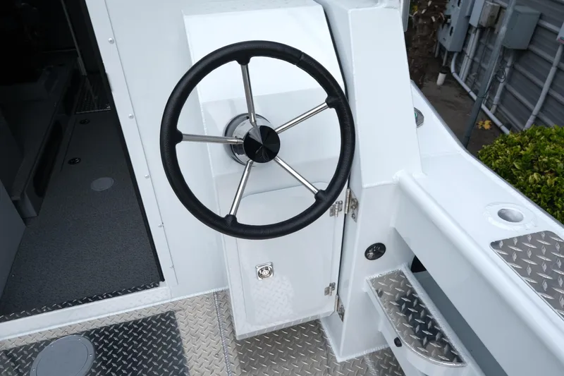 Slide: The Image of Steering wheel of 2025 Hewescraft 270 Alaskan boat, featuring sleek design and metal accents. - 10