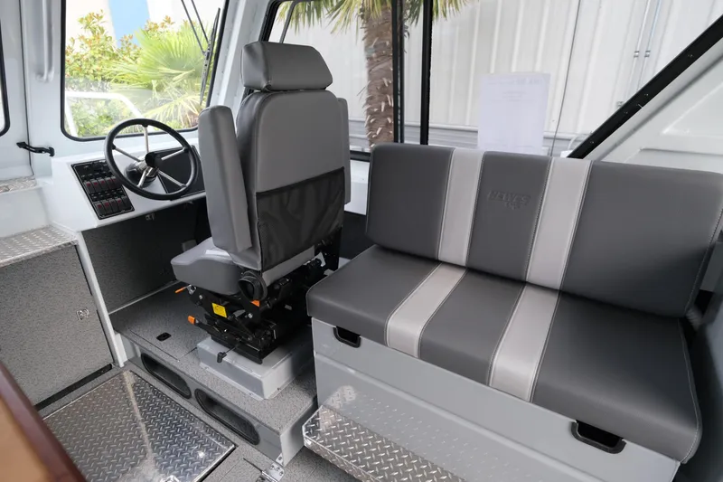 Slide: The Image of 2025 Hewescraft 270 Alaskan boat interior with steering wheel and seating. - 13