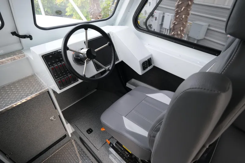 Slide: The Image of 2025 Hewescraft 270 Alaskan boat interior with steering wheel and captain's seat. - 14
