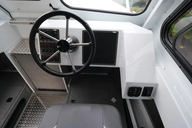 Slide: The Image of 2025 Hewescraft 270 Alaskan boat interior with steering wheel and control panel. - 15
