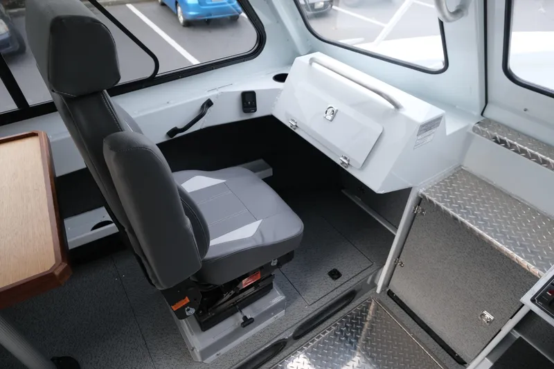 Slide: The Image of 2025 Hewescraft 270 Alaskan interior with captain's chair and storage compartment. - 17
