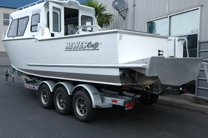 Slide: The Image of 2025 Hewescraft 270 Alaskan boat on trailer, parked outside a building. - 3
