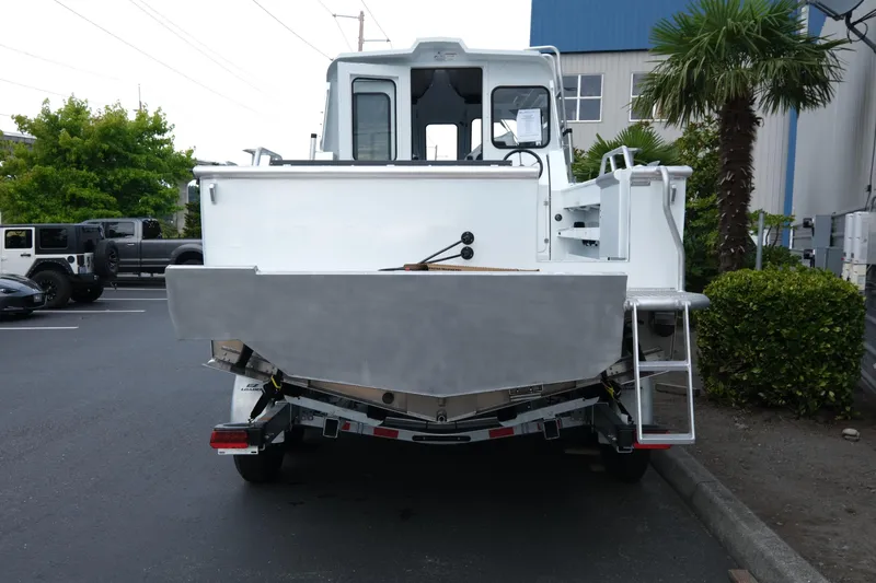 Slide: The Image of 2025 Hewescraft 270 Alaskan boat, rear view, parked outdoors near palm trees. - 4