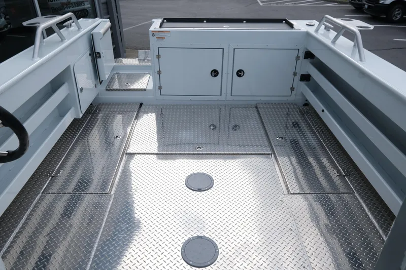 Slide: The Image of Interior of 2025 Hewescraft 270 Alaskan boat with diamond plate flooring and storage compartments. - 9