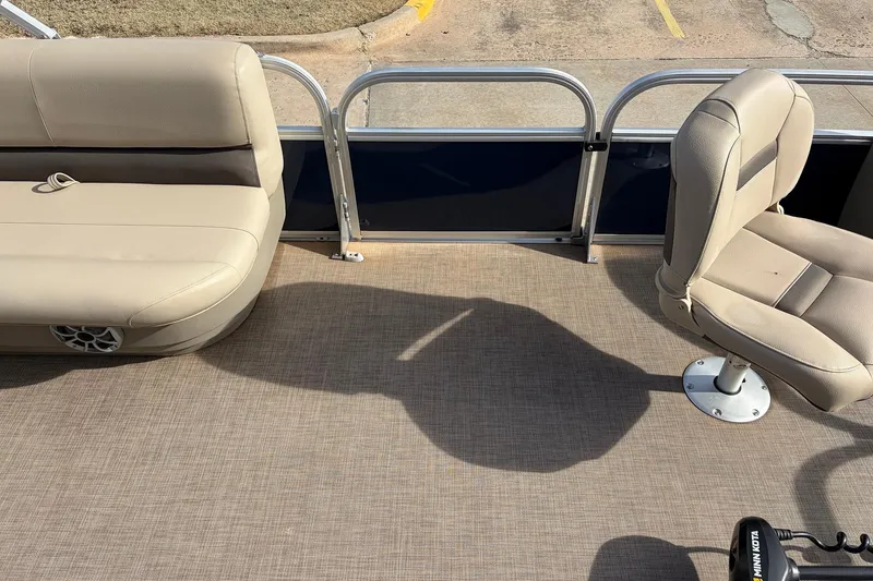Slide: The Image of 2025 Sun Tracker Bass Buggy 18 DLX interior with beige seating and carpeted floor. - 18