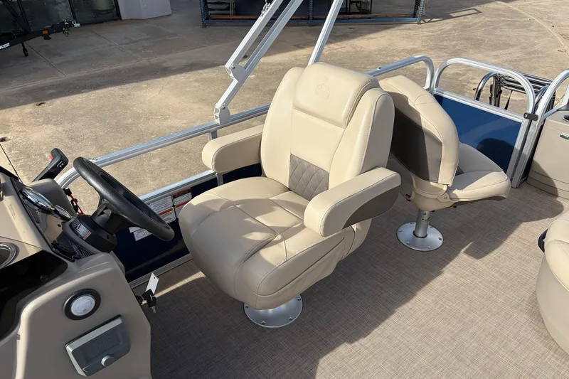 Slide: The Image of 2025 Sun Tracker Bass Buggy 18 DLX boat interior with beige captain's chair and steering wheel. - 24