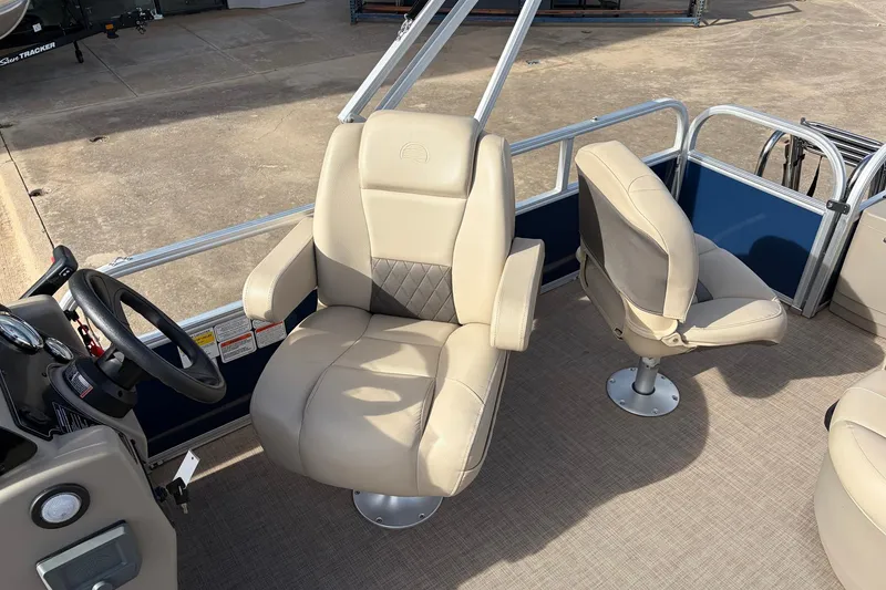 Slide: The Image of 2025 Sun Tracker Bass Buggy 18 DLX interior with beige captain's chairs and steering wheel. - 28