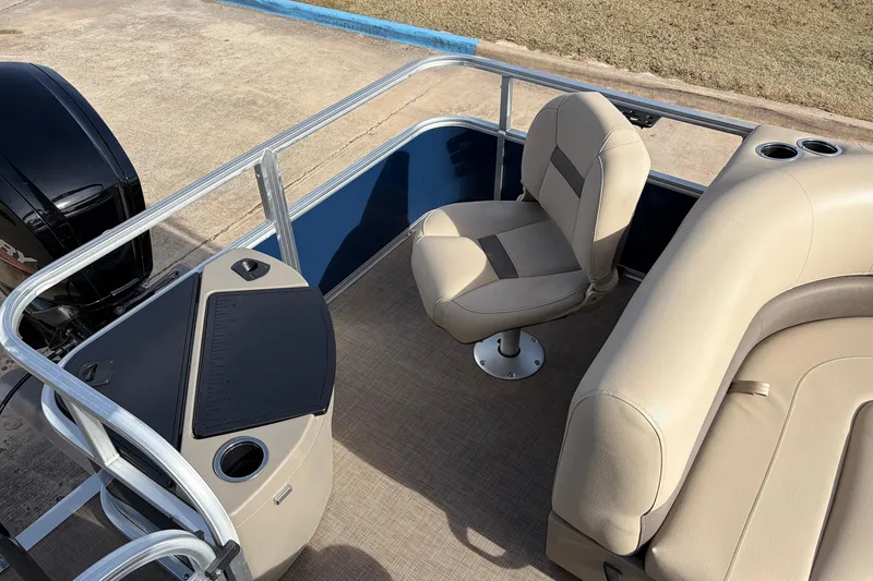 Slide: The Image of 2025 Sun Tracker Bass Buggy 18 DLX pontoon boat interior with beige seating and console. - 29