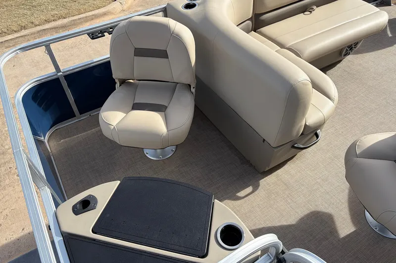Slide: The Image of 2025 Sun Tracker Bass Buggy 18 DLX interior with beige seating and carpeted floor. - 30