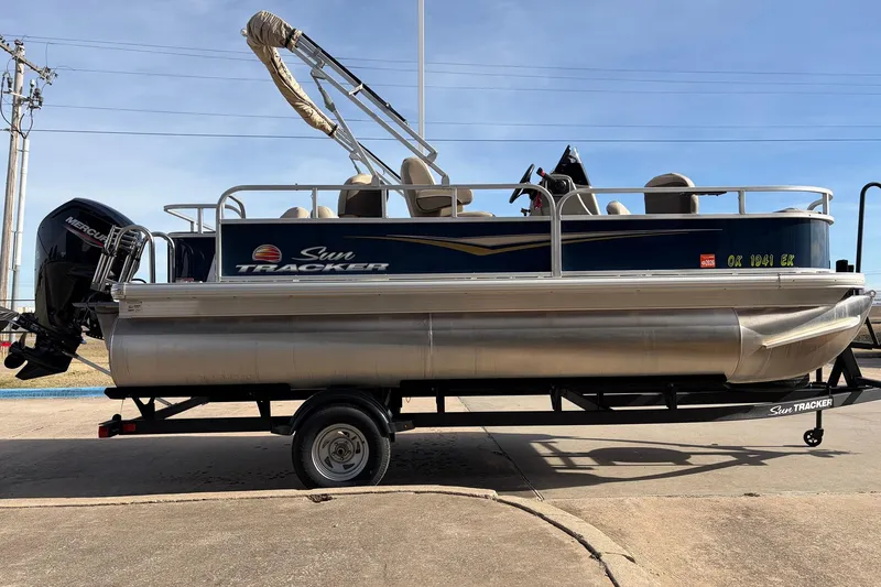 Slide: The Image of 2025 Sun Tracker Bass Buggy 18 DLX pontoon boat on trailer, side view. - 4