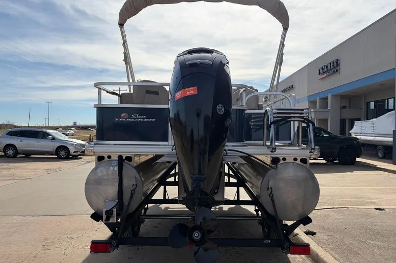Slide: The Image of 2025 Sun Tracker Bass Buggy 18 DLX pontoon boat at dealership, rear view. - 6