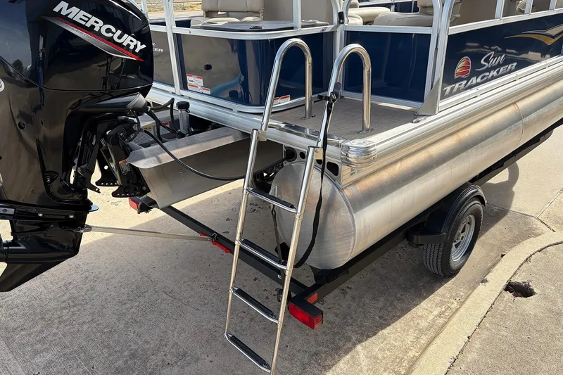 Slide: The Image of 2025 Sun Tracker Bass Buggy 18 DLX pontoon boat with Mercury engine and boarding ladder. - 8