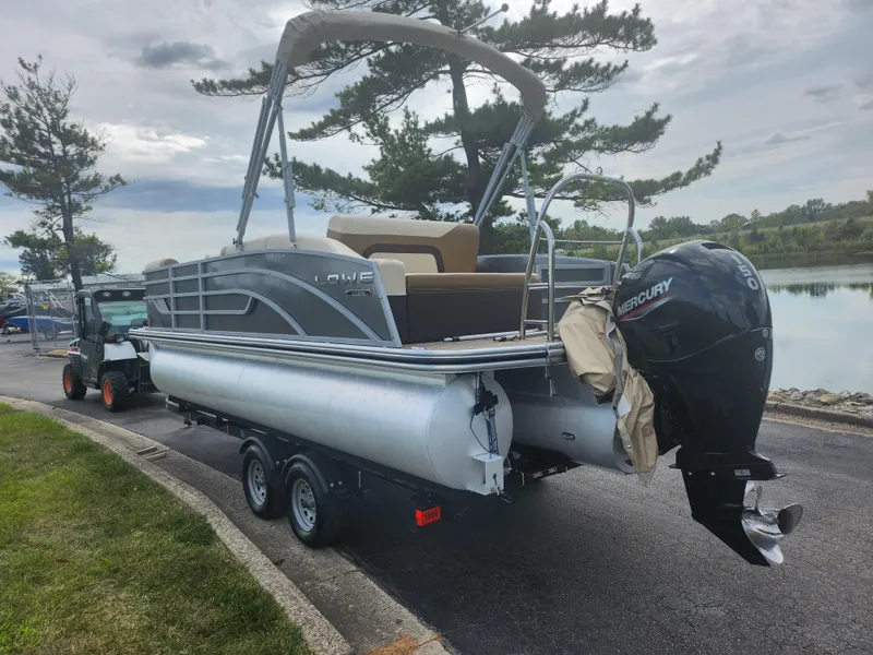 Slide: The Image of Pontoon boat Lowe SS 210 CL 2022 on trailer by lakeside, featuring Mercury outboard motor. - 1