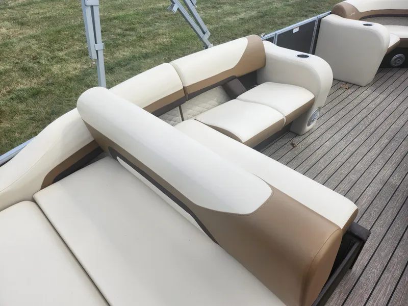 Slide: The Image of 2022 Lowe SS 210 CL boat interior with beige and brown seating on wooden deck. - 15
