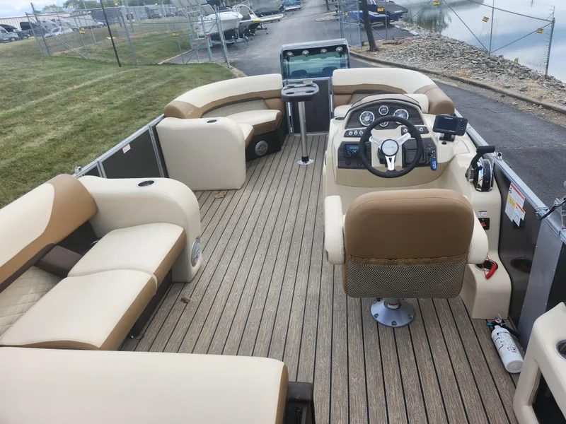 Slide: The Image of 2022 Lowe SS 210 CL pontoon boat interior with beige seating and modern dashboard. - 16