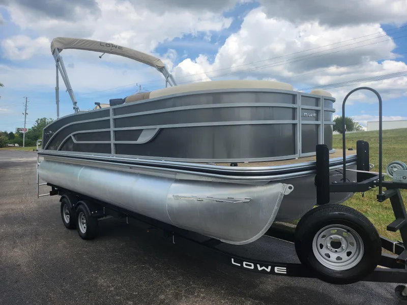 Slide: The Image of 2022 Lowe SS 210 CL pontoon boat on trailer under cloudy sky. - 5