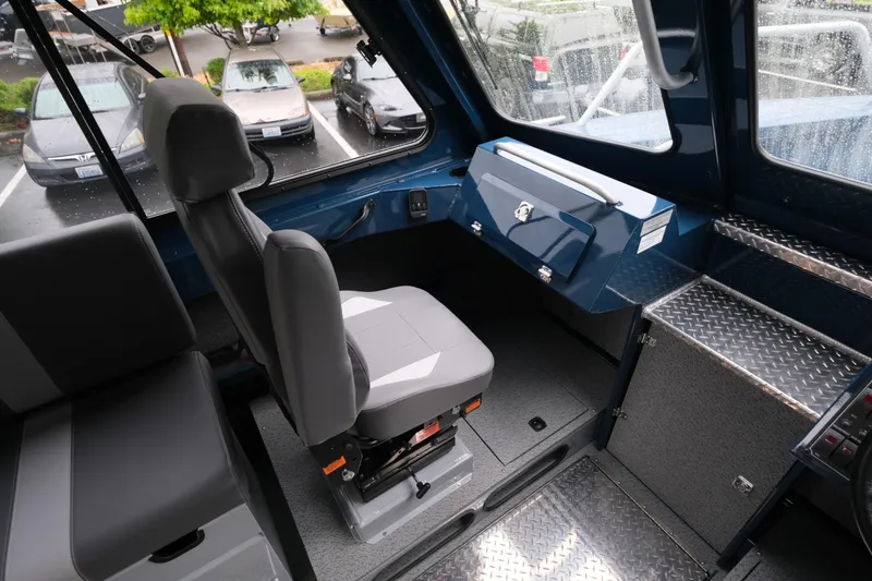 Slide: The Image of Interior of 2025 Hewescraft 270 Alaskan boat, featuring captain's seat and control panel. - 17