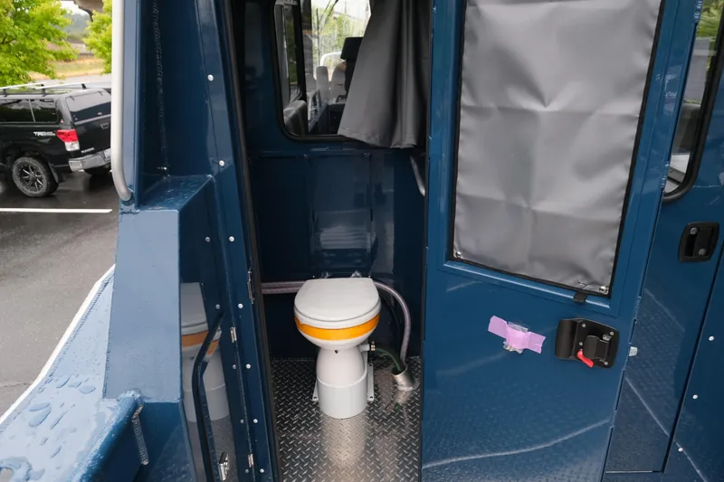 Slide: The Image of 2025 Hewescraft 270 Alaskan boat interior with compact marine toilet. - 19