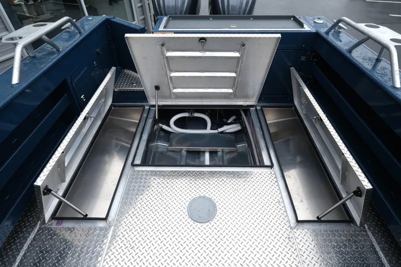 Slide: The Image of 2025 Hewescraft 270 Alaskan boat interior with open storage compartments and diamond plate flooring. - 21