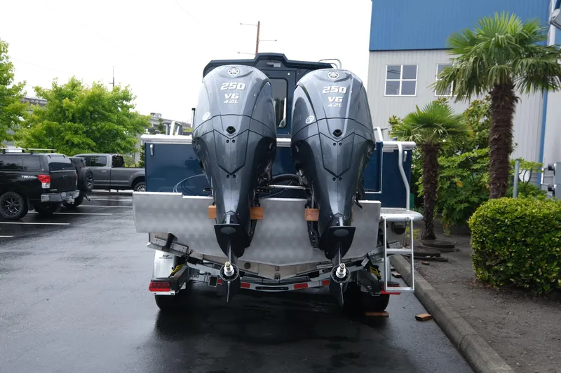 Slide: The Image of 2025 Hewescraft 270 Alaskan boat with dual Yamaha 250 V6 engines in a parking lot. - 6