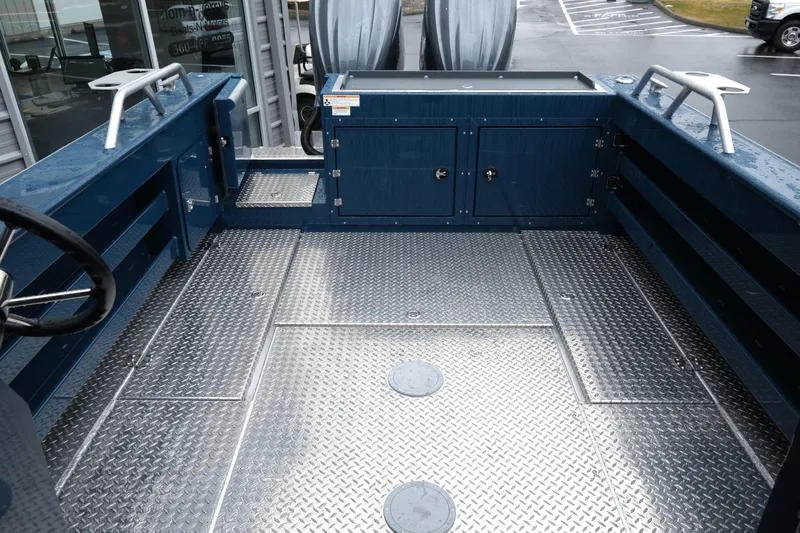 Slide: The Image of 2025 Hewescraft 270 Alaskan boat interior with diamond plate flooring and storage compartments. - 8