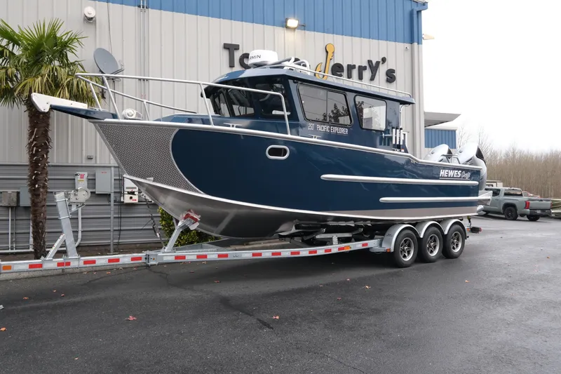 The Image of 2026 Hewescraft 250 Pacific Explorer boat on trailer outside a building. - 1