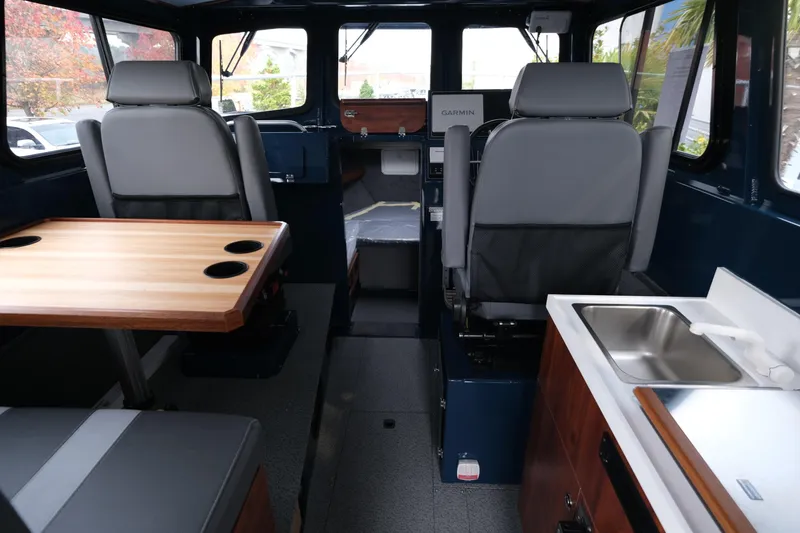 Slide: The Image of Interior of 2026 Hewescraft 250 Pacific Explorer with seating, table, and sink. - 10