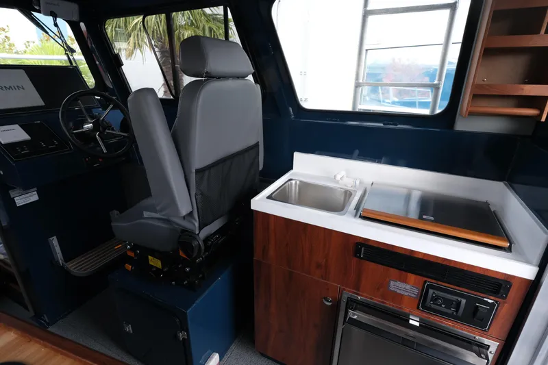 Slide: The Image of Interior of 2026 Hewescraft 250 Pacific Explorer with helm and kitchenette. - 12