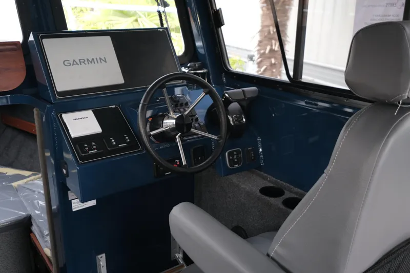 Slide: The Image of 2026 Hewescraft 250 Pacific Explorer helm with Garmin navigation and Honda controls. - 14